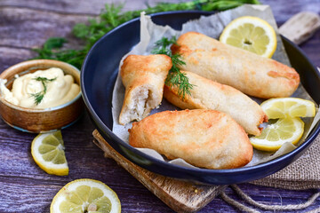   Allasca Pollock Fish  Bites in a crispy Tempura  Batter.Fish and chips .Close up of   crispy breaded  deep fried fish fingers with breadcrumbs s erved with remoulade sauce and  lemon