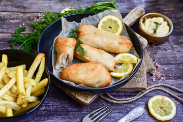   Allasca Pollock Fish  Bites in a crispy Tempura  Batter.Fish and chips .Close up of   crispy breaded  deep fried fish fingers with breadcrumbs s erved with remoulade sauce and  lemon