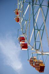 Ferris wheel, booths against the blue sky.