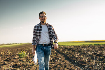 A happy man is walking in the field on a sunny day.