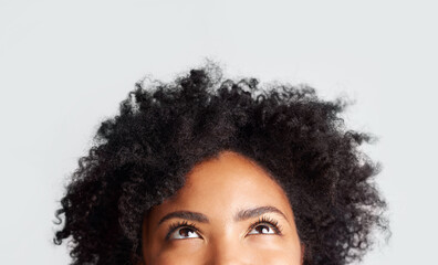 Woman, eyes looking up and cropped in studio with thinking, ideas and hope by gray background. Young female model, african girl and think for mindset with afro, vision and daydream by backdrop - obrazy, fototapety, plakaty