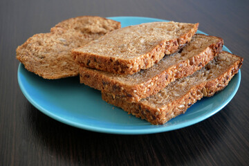whole grain bread in plate on wooden background, Organic Homemade Whole Wheat Bread, closeup