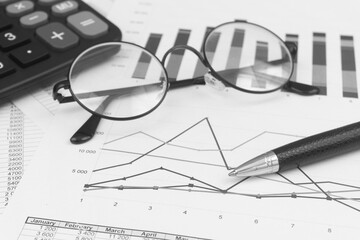 Market statistics, calculator, eyeglasses and pen close-up. Business concept.