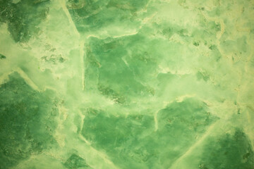 Green background from decorative plaster with abstract spots. Unusual green wall texture with beautiful patterns, creative surface background. Front covering for facing of buildings.