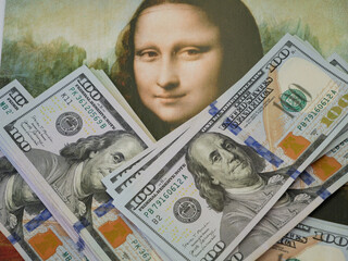 A lot of dollars USA money against the background of an old painting Mona Liza La Gioconda from...