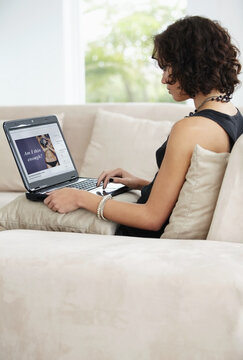 Young woman, anorexia and laptop reading on diet, health or person working online from living room couch. Computer, body image and peer pressure in media or technology, eating disorder at home