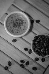 Obraz na płótnie Canvas Flatlay a cup of coffee with coffee beans with black and white effect