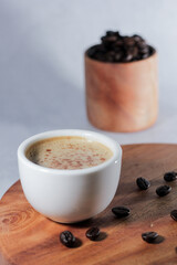 A cup of coffee with coffee beans with blurred background