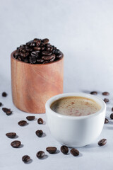 A cup of coffee with coffee beans with blurred background