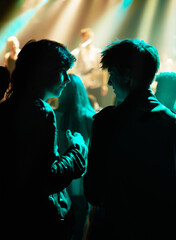 Neon, friends and fans at music festival, lights and crowd in silhouette at live band performance...