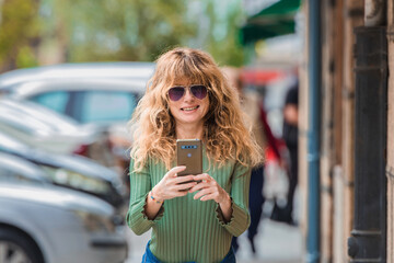 mature woman using mobile phone in the street