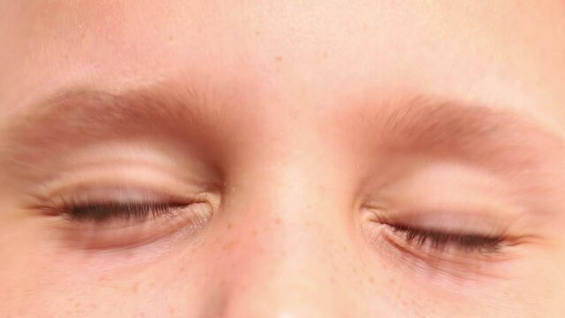Close up video shot cropped frightened little girl blue eyes squinting, closing eyes tight, looking, blinking at camera. Children fear and pain. Foster family and adoption. Kid protection and safety.