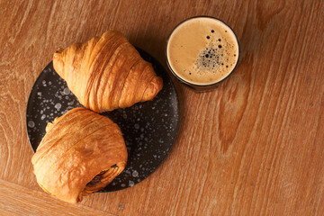 plain croissant pain au chocolate black coffee on wood background