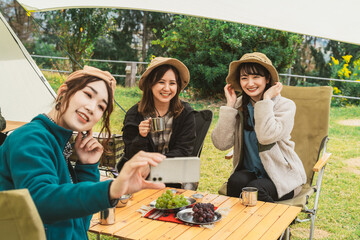 秋冬のアウトドア・キャンプ場にキャンプに来た女性達（女子キャンパー・友達・アジア人）
