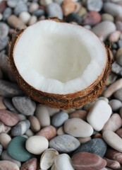 Fresh Ripe Split Coconut With White Flesh Inside On A Smooth Colorful Pebbles Close Up Stock Photo