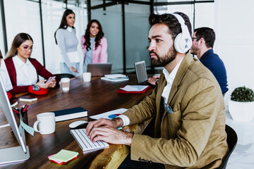 young latin businessman working and using computer or laptop in smart casual clothes at office in Mexico, hispanic people