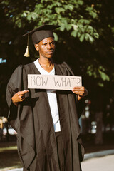 Portrait of disappointed afro american guy holding cardboard poster and lending hand on street....