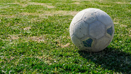Single vintage old football ball on green grass  - Powered by Adobe