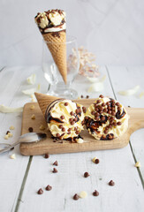 
Vanilla chocolate ice cream cone. On a white wooden background. Sweets