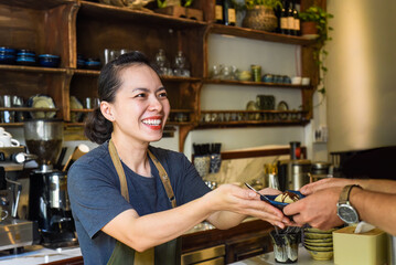 Vietnamese waitress serving ice cream for a customer in a coffee shop