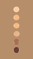 Diverse skin tone makeup foundation drops on brown background.
