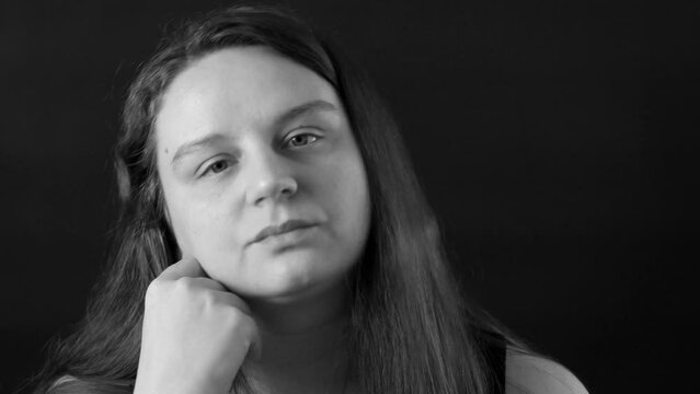 Black and white portrait of upset middle-aged woman with long hair leaning head on hand, shaking head, touching cheek with finger, showing refusal, gesturing. Negative emotions, no, disappointment.