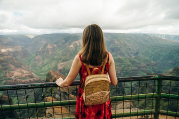 girl taking picture on phone ingirl taking picture on phone in waimea canyon