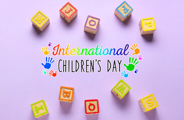 Colorful cubes and text INTERNATIONAL CHILDREN'S DAY on lilac background