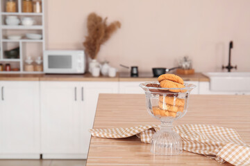 Glass bowl with cookies and napkin on dining table in kitchen