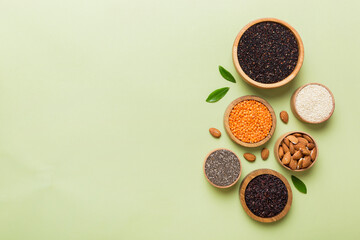 Various superfoods in smal bowl on colored background. Superfood as rice, chia, quinoa, lentils, nuts, sesame seeds, almonds. top view copy space
