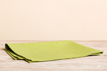 top view with green kitchen napkin isolated on table background. Folded cloth for mockup with copy...