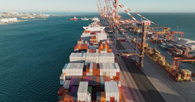 Close-up aerial fly over.Containers and Container ships at the dock in a harbour. Global supply chain.Logistics.Distribution