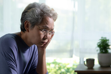 Portrait of sad and lonely Asian senior woman in living room