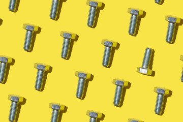 a lot of iron screws bolts on a bright yellow background. pattern repair