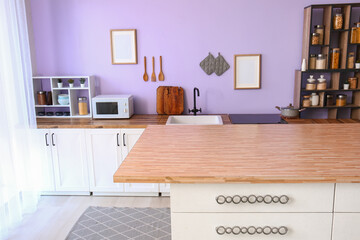 Interior of modern kitchen with clean table and white counters