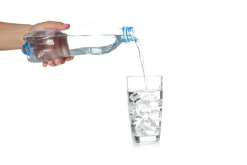 Female hand pour water in glass from bottle, isolated on white background