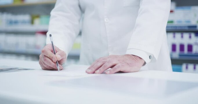 Man, pharmacist and hands writing note, diagnosis or medical prescription on desk at pharmacy. Hand of male healthcare professional filling in document, form or paperwork on counter at the clinic