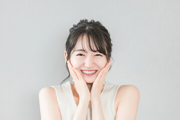 正面から見たアジア人女性の笑顔（美容・エステ・スキンケアイメージ）
