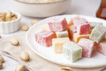 Plate with tasty Turkish Delight on light background, closeup