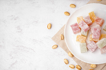 Plate with tasty Turkish Delight on light background
