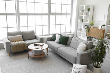 Interior of bright living room with cozy grey sofas and coffee table
