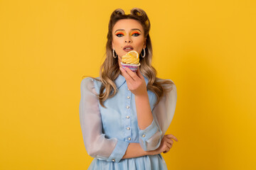woman eating a cookie, model in studio yellow background