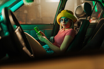 Retro woman playing video game in car.
