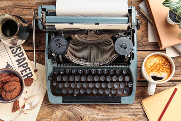 Cup of coffee with typewriter, cookies, cezve and newspaper on wooden background