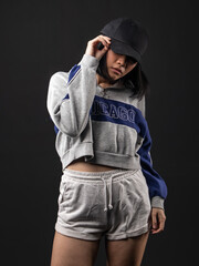 A portrait of a casual fashion-style Asian (Chinese Indonesian) Girl posing dan dancing with a Hip hop style. Isolated on a black background