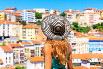 Fototapeta premium Woman tourist looking at panoramic view of portuguese skyline- Travel in Portugal, colorful houses- Coimbra