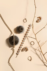 Fototapeta premium Ikebana kenzans with jewelry and tree branch on beige background