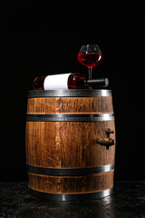 Wooden barrel with bottle and glass of wine on dark background