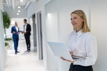 Pleased thoughtful business lady with the laptop in the hands