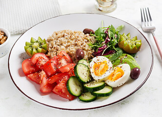 Breakfast oatmeal porridge with boiled eggs, fresh salad and kiwi. Healthy balanced food.